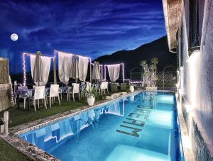 a large swimming pool with chairs and a table at Re dream suite a tema - Rapallo in Rapallo
