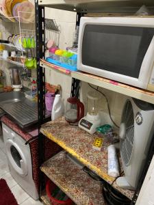 a microwave sitting on a shelf next to a refrigerator at شقة 2 غرفة كبيرة ترى البحر مباشر مكيفة وسط المدينة in Port Said