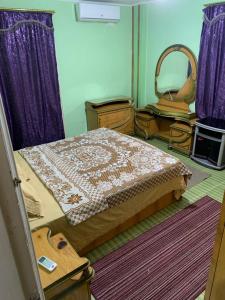sypialnia z łóżkiem z fioletowymi zasłonami i lustrem w obiekcie شقة 2 غرفة كبيرة ترى البحر مباشر مكيفة وسط المدينة w mieście Port Said