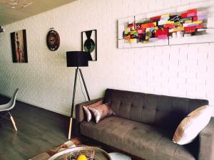 a living room with a couch and a white wall at Modern Apartments in Cape Town