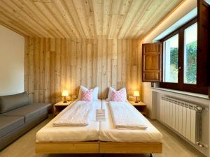 ein Schlafzimmer mit einem Bett, einem Sofa und Fenstern in der Unterkunft Villa Ginevra Resort Agrituristico in Ficarra