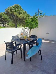a table with four chairs at Arismari Apartments in Zíros
