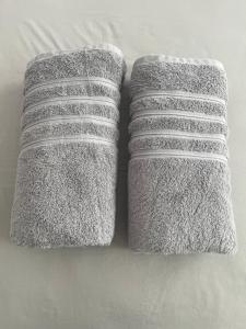 dos toallas sentadas encima de una cama en Habitaciones privadas en un departamento encantador, en Panamá