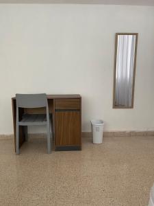 a desk in a room with a mirror and a trash can at Habitaciones privadas en un departamento encantador in Panama City