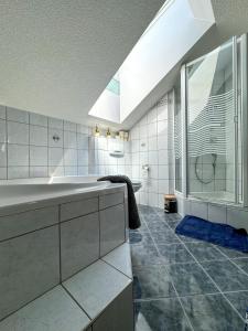 bagno con vasca, lavandino e doccia di Stadt & See Appartement Penthouse inkl MIC Card a Spittal an der Drau