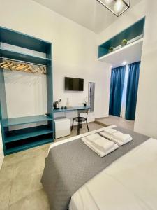 a bedroom with a bed with a desk and a tv at Bausan Avenue in Naples