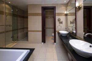 un bagno con due lavandini e una cabina doccia di 2 BHK Townhouse at Pearl a Doha