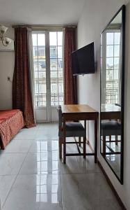 Zimmer mit einem Tisch und einem Spiegel sowie einem Schlafzimmer. in der Unterkunft Astoria Hotel in Buenos Aires