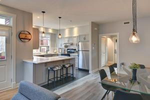 een keuken en woonkamer met een tafel en stoelen bij Tremblant Prestige - Les Eaux 207-2 in Mont-Tremblant +22 foto's