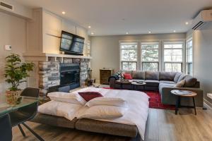 sala de estar con sofá y chimenea en Les Eaux 207-2 Mountain adventure en Mont-Tremblant