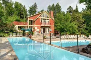 a home with a swimming pool in front of a house at Les Eaux 207-2 Mountain adventure in Mont-Tremblant