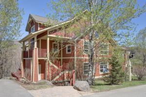 a large red brick house with a porch at Les Eaux 207-2 Mountain adventure in Mont-Tremblant