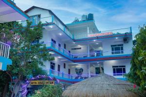 a large white building with blue trim at Hotel Shiva's Dream in Sauraha