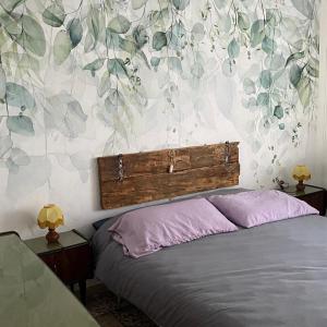 1 dormitorio con 1 cama y papel pintado con motivos florales en B&B Ca' dal Sol, en Selvanizza