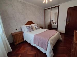 - une chambre avec un grand lit et un miroir dans l'établissement Apartamento Xanela o Mar, à Laxe