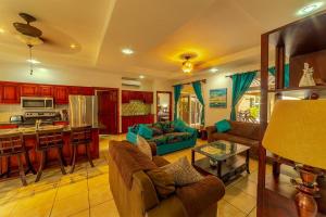 a living room with a couch and a kitchen at Villa Felicidad By Vacation Pura Vida in Esterillos