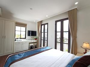 a bedroom with a bed and a kitchen with windows at Khách sạn Time Lotus Hạ Long in Ha Long