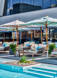 a group of chairs and umbrellas next to a pool at The William Vale in Brooklyn