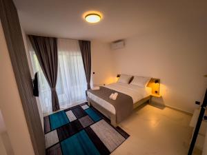 a bedroom with a bed and a large window at Sunny Corner Apartments in Visoko