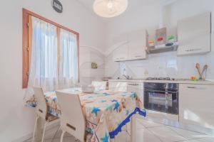 y cocina con mesa, sillas y fogones. en Appartamento Le Conchiglie - Goelba, en Portoferraio 15 fotos más