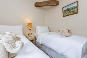 two beds sitting next to each other in a bedroom at River Garden Cottage in Dean