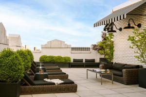 a rooftop patio with couches and tables on a building at Sonder at One Platt in New York