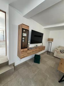 a living room with a flat screen tv on a wall at Au Fil De L'Aure in Monfréville