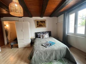a bedroom with a bed with a book on it at Meunier tu dors ! au pied du Moulin in Porrentruy