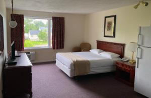 um quarto de hotel com uma cama e uma janela em The Fort Nashwaak Motel em Fredericton