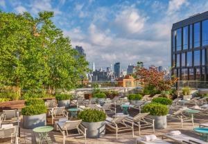 a patio with chairs and tables and a city skyline at The William Vale in Brooklyn