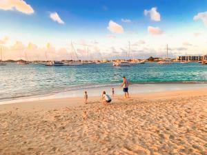 a man and two children playing on the beach at Simpson Bay Resort Marina & Spa in Simpson Bay