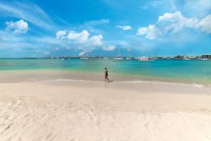 a man walking on a beach near the water at Simpson Bay Resort Marina & Spa in Simpson Bay