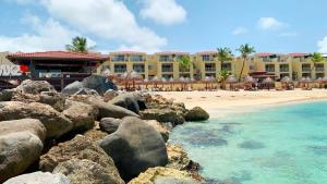 a resort with a beach and some rocks and the ocean at Simpson Bay Resort Marina & Spa in Simpson Bay