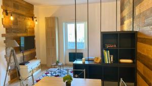 ein Wohnzimmer mit einem Schreibtisch und einem Fenster in der Unterkunft Chaleureuse Échappée : Commodités, Calme, Confort in Angers
