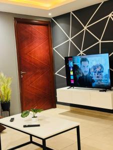 Una televisión o centro de entretenimiento en One Bed Apartment In GoldCrest Mall And Residency