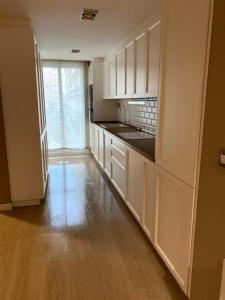 a kitchen with white cabinets and a wooden floor at Apartamento Moderno Centro Bilbao in Bilbao