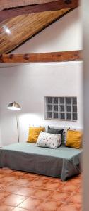 a bedroom with a bed with yellow and white pillows at Alojamiento 13 Jotas in Iniesta