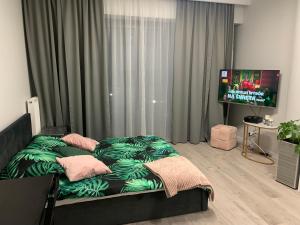 a bedroom with a bed and a flat screen tv at Hanza Tower De Lux apartament in Szczecin +20 photos
