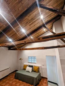 ein Schlafzimmer mit einem Bett in einem Zimmer mit Holzdecken in der Unterkunft Alojamiento 13 Jotas in Iniesta