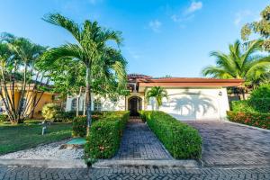 une maison avec des palmiers et une allée dans l'établissement Villa Encanto By Vacation Pura Vida, à Bejuco