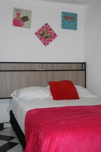 a bed with a red blanket and two hearts on the wall at Aparta Suite Torre De Prado 302 in Medellín