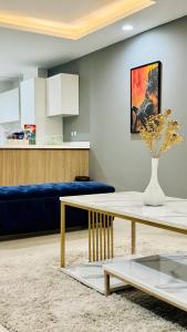 salon ze stołem i niebieską kanapą w obiekcie One Bed Apartment In GoldCrest Mall And Residency w mieście Lahaur