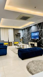 un soggiorno con divani blu e TV a schermo piatto di One Bed Apartment In GoldCrest Mall And Residency a Lahore