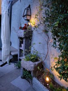 una panca di pietra con piante e una luce su un muro di Casa Gelsomino, Laglio, Lake Como a Laglio