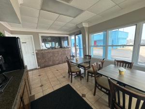 uma cozinha com uma sala de jantar com mesas e cadeiras em Econo Lodge Galveston Seawall em Galveston