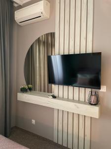 telewizor z płaskim ekranem zamontowany na ścianie w obiekcie City view in Residences w Burgas