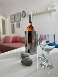 una bottiglia di vino e due bicchieri su un tavolo di PEBBLE Apartman ZADAR a Zara (Zadar)