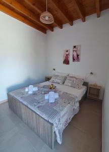 a bed in a white room with a table at Arismari Apartments in Zíros