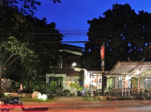 a building with a sign in front of it at night at Chiang Mai D Hostel in Chiang Mai