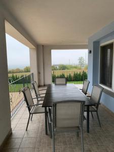 eine Terrasse mit einem Tisch und Stühlen auf dem Balkon in der Unterkunft Balatonview - villa Myriam in Nemesbükk